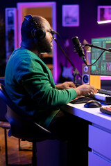 Skilled artist composing a new song with his lyrics and piano tunes, recording audio files to edit them with mixing and mastering techniques. Young talented musician produces music.