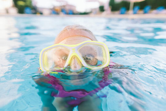 Girl wearing googles swimming in pool