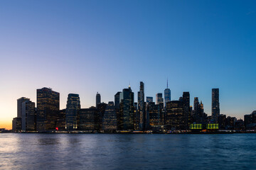 Naklejka premium Manhattan skyline at dusk over the river, New York City.