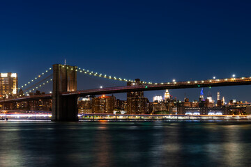 Fototapeta premium Brooklyn Bridge at Night with Manhattan Skyline in Background.