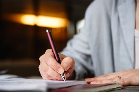 Hand of businesswoman writing with pen