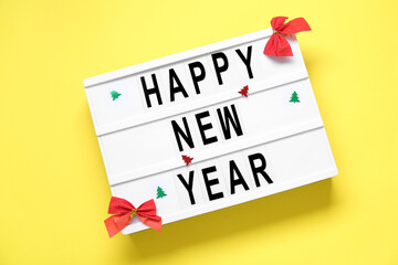 Board with text HAPPY NEW YEAR on yellow  background