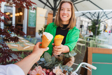 Friends having ice cream cones in sidewalk cafe