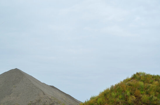 Open-pit mine of potassium near hill under sky