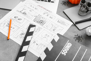 Clapperboard with laptop and storyboard on grunge grey background. Halloween celebration