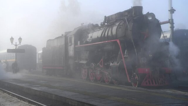 Steam locomotive of the retro train in the morning October fog. Sortavala, Karelia