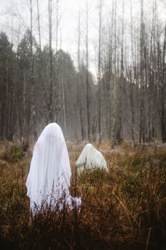 Ghosts standing amidst plants in forest