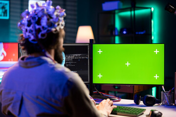 Man with EEG headset programs brain transfer into green screen computer virtual world, merging with...