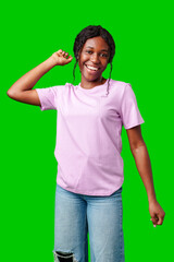 Joyful woman celebrating success with clenched fists against a bright green background