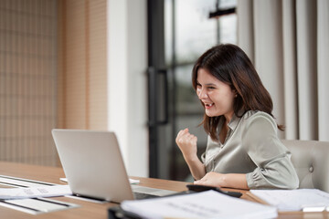 Happy Business Woman Celebrates Success at Work with Fist Pump in Modern Office Environment