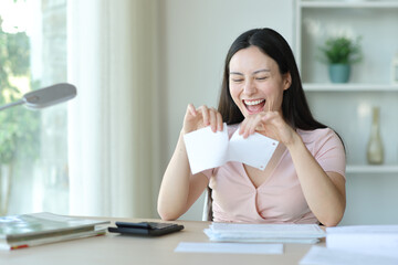 Happy asian woman breaking receipt or bill at home