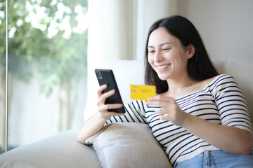 Happy asian woman buying online at home