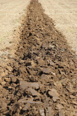 Deep furrows in the ground after working the tractor with the plow