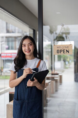 Confident Female Barista and Coffee Shop Manager Holding Tablet in Modern Cafe Setting