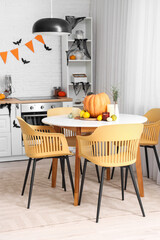 Interior of light kitchen decorated for Halloween with dining table