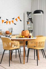 Interior of light kitchen decorated for Halloween with dining table