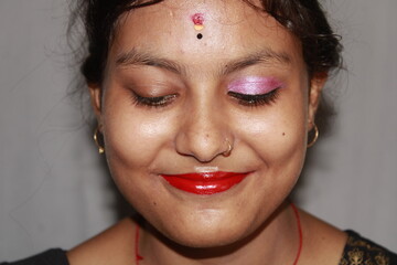 Vibrant red lips curve upwards in a joyful smile. Perfect natural lip makeup. Close up macro photo with beautiful Indian teenage girl mouth.