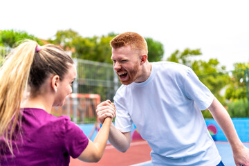 Pickelball players shaking hands celebrating victory on a court