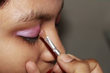 Makeup artist apply makeup brush for eyes. makeup for young Indian girl, Pink eyeshadow close up