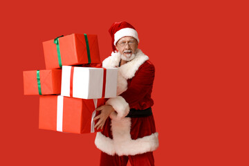 Santa Claus with many gift boxes on red background