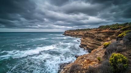Obraz premium 83. A deserted coastal cliff with crashing waves below and a cloudy sky