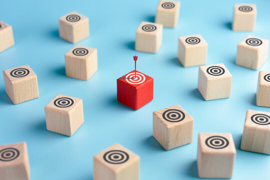 Target audience targeting concept. Red arrow hits a target circle on red wooden cube. Market research. Bulls-eye. Marketing. High advertising efficiency.