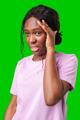 A woman expressing frustration while standing in front of a bright green background