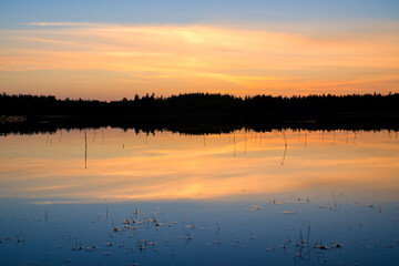 Obraz premium Sunset with warm colors on a Swedish lake in Smalland. Romantic evening atmosphere