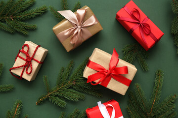 Composition with Christmas branches and gift boxes on green background. Top view
