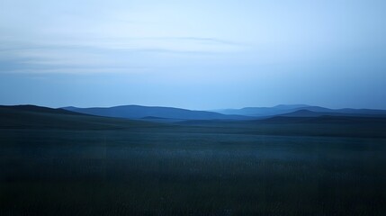 Fototapeta premium 57. A vast plain at twilight, with silhouettes of distant hills against the sky