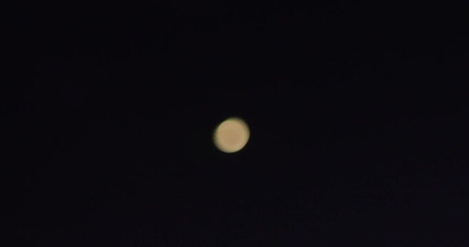 The crescent moon melts into a soft, circular blur.