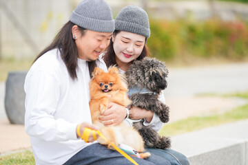 A Korean man and a Japanese woman, both in their 30s, are walking three dogs along the riverside in Pyeongnae-dong, Namyangju-si, Gyeonggi-do, Korea.
