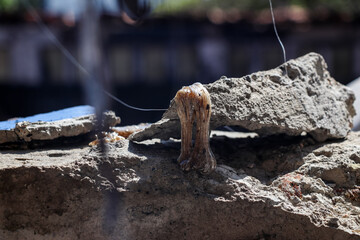 Melted plastic fibers left over from a building fire that fell and stuck to chunks of cement wall