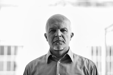 Fototapeta premium Senior manager posing in black and white with city in background