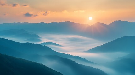 Obraz premium Fog rolling over a mountain range at dawn, with the sun barely visible through the mist
