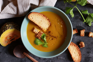Creamy pumpkin soup in a bowl. Healthy food in Autumn season.