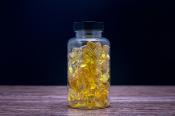A bottle of fish oil pills sits on a wooden table