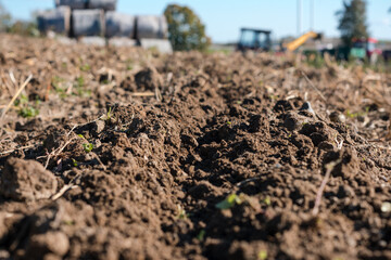 Dirt field with a tractor in the background
