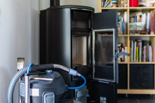 Cleaning a pellet stove with a vacuum cleaner and a brush
