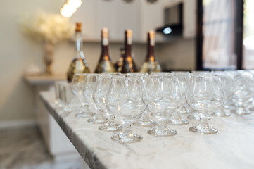 A lot of empty wine glasses. Row of clean glass transparent glasses are on a table on banquet in a bar