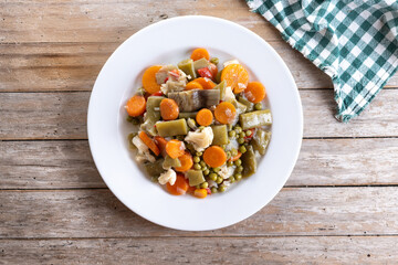 Vegetable stew (menestra de verduras) on wooden table. Top view