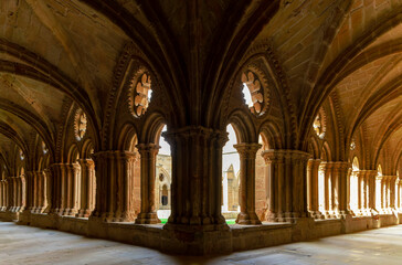 Fototapeta premium Cloister of a Cistercian monastery. The inside of a building with arched windows and a long hallway
