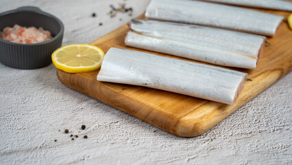 가지런한 도마위의 갈치와 레몬 슬라이스 소금과 후추
