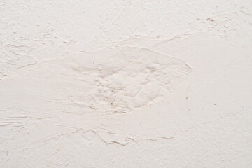 White plastered wall with visible texture, rough surface, and irregular patterns, showcasing an abstract design.