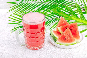 Trendy watermelon beer. Traditional Oktoberfest drink, kvass with palm leaves. Modern beverage
