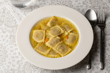 Ravioli in brodo. Fresh Meat italian dumplings, pasta with meat filling in vegetable broth.