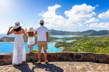 A family on tropical holidays enjoys the panoramic view over the landscape of Antigua island with...