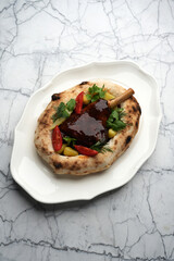 Fried Duck leg with vegetables and sauce in a pita bread