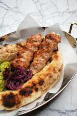 Chicken lula kebab with vegetables and pita bread