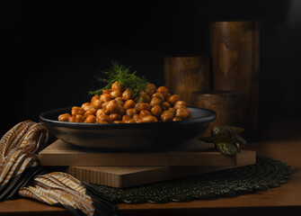 Dark and moody capture of traditional chick pea, nohut dish with green pickles and dills
